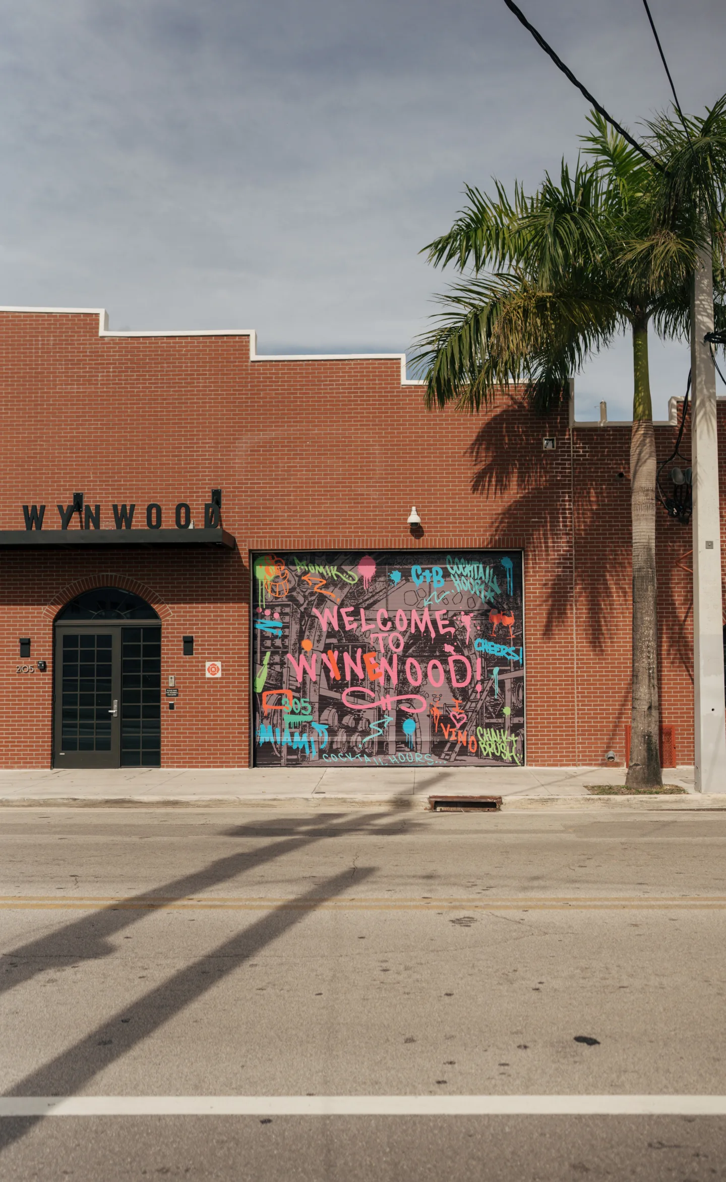 Welcome to Wynwood mural on a palm-lined Miami street