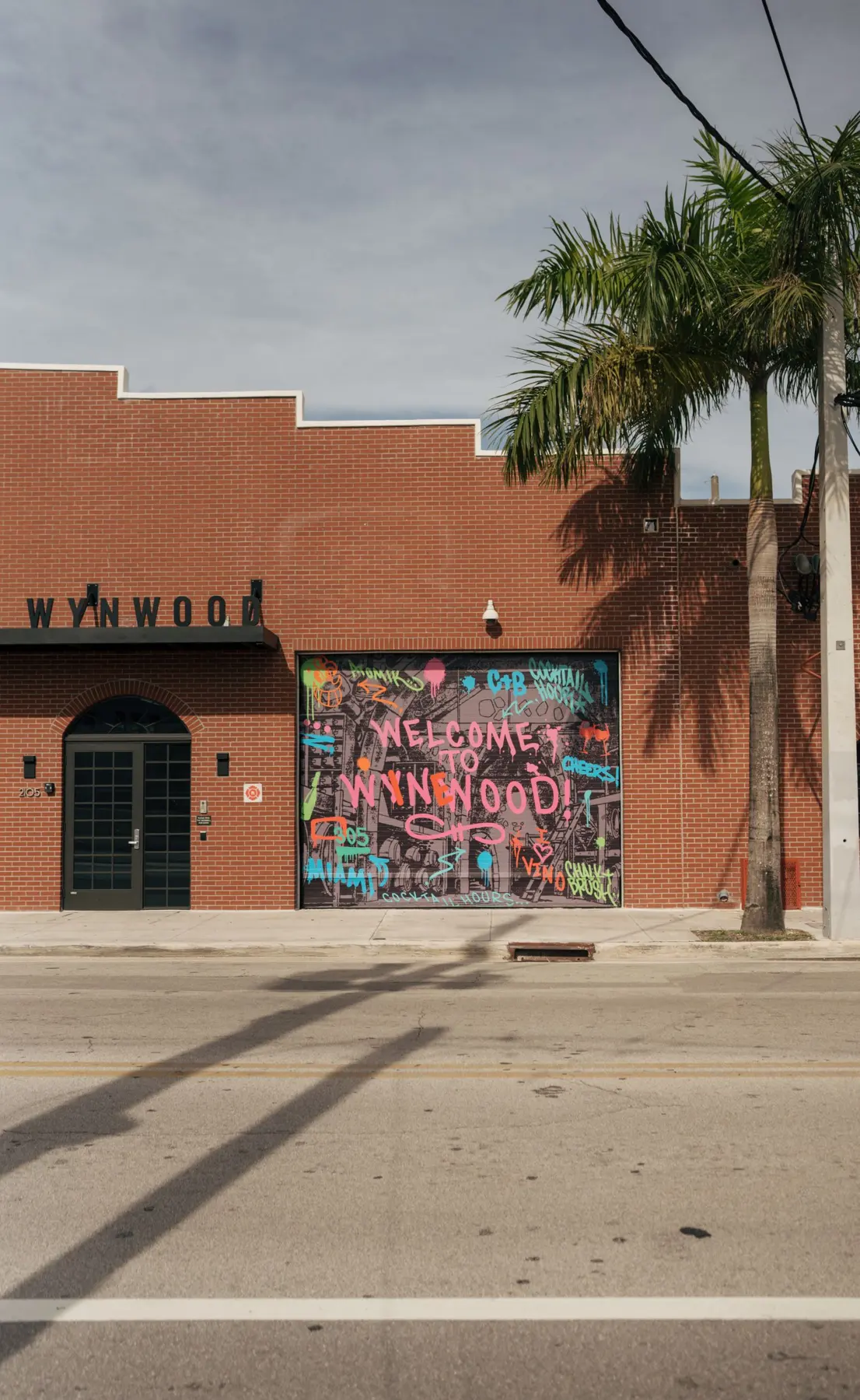 Welcome to Wynwood mural on a palm-lined Miami street