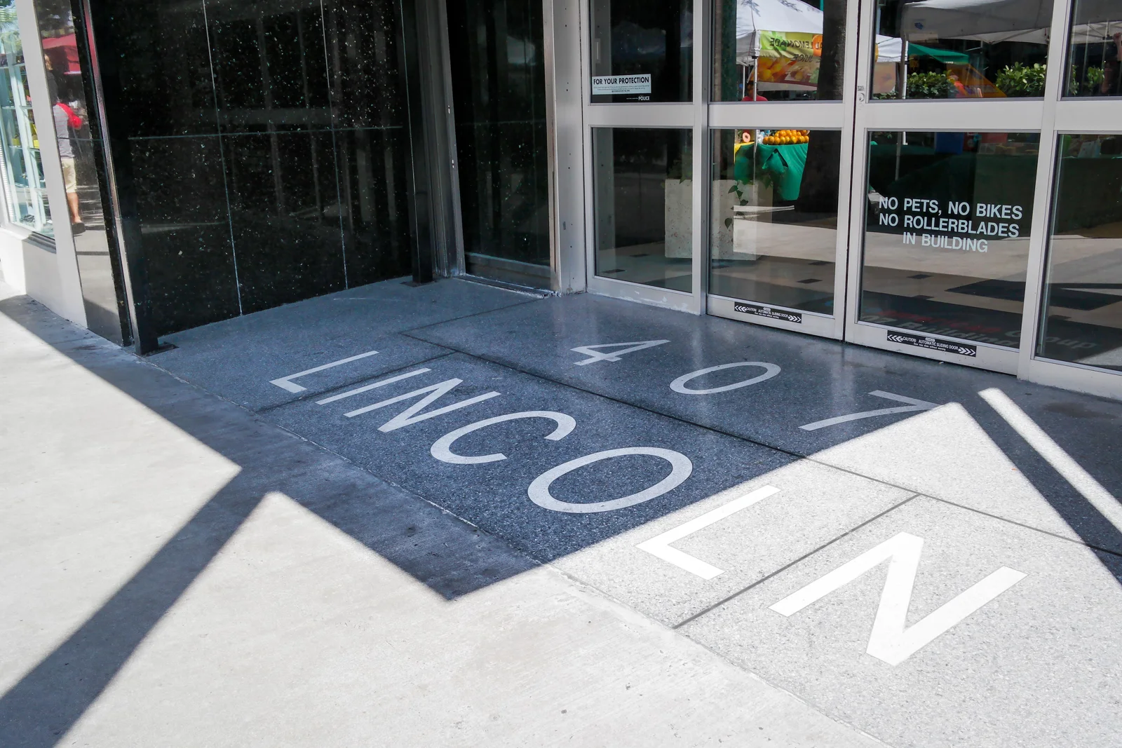 Glass entrance doors and the 407 Lincoln Road lettering on the pavement in Miami Beach